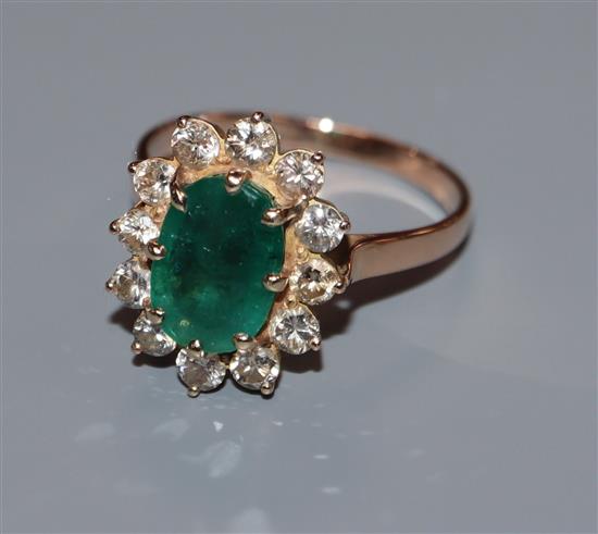 A yellow metal, emerald and diamond set oval cluster ring, size Q.